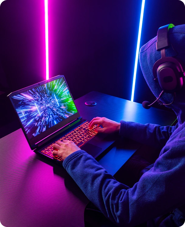 Gracz gra na laptopie i analizuje strategiczną grę w ciemnym pomieszczeniu gamingowym